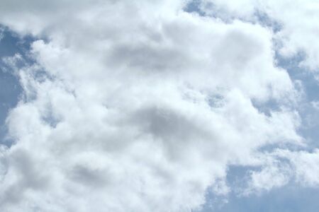 Clouds in the blue sky at sunset or dawn backlit by the sun. Place for text and design.の写真素材