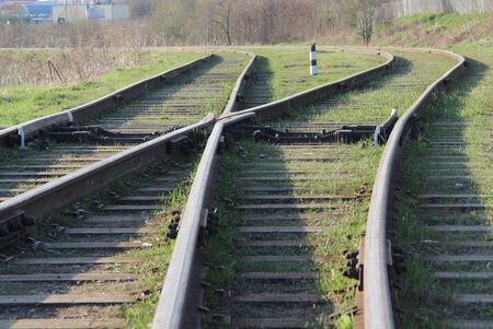 The railway stretching into the distance against the background of young green grass and trees in spring.の写真素材