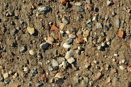 Small stones and sand. The natural texture of the soil. Shore of a reservoir with a beach and pebbles.の写真素材
