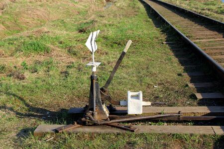 Railway arrow in black with a lever and pointer in Russia. The device for the transfer of rails at intersections for trains. Technical element of the railway industry.の写真素材