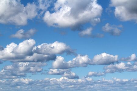 White fluffy clouds on a background of blue sky in summer. The concept of weather and climate.の写真素材
