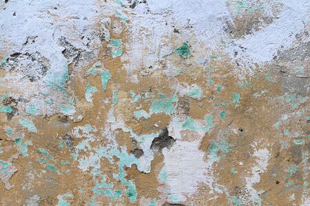 Old cracked wall covered with stucco with abstract watercolor blue, pink and ebony spots of paint. Multicolored vintage background for wallpaper, background and scrapbooking.の写真素材
