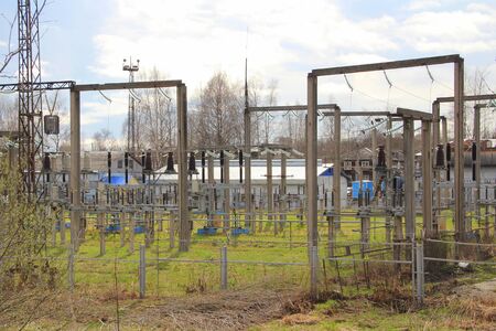 The power station. High voltage structures on green grass. Cables, wires and ceramic insulators.の写真素材