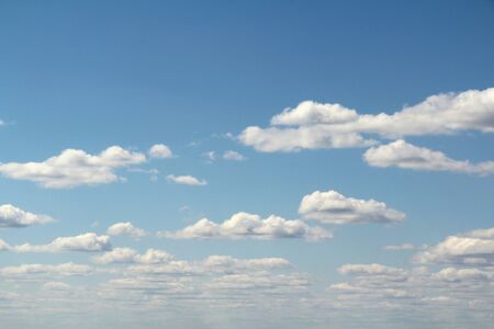 White fluffy clouds on a background of blue sky in summer. The concept of weather and climate.の写真素材
