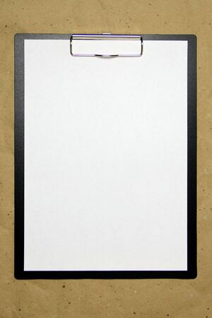 A tablet with a white sheet of A4 format on a beige craft paper. Concept of new opportunities, ideas, undertakings, innovations. Stock photo with empty place for your text and design.の写真素材
