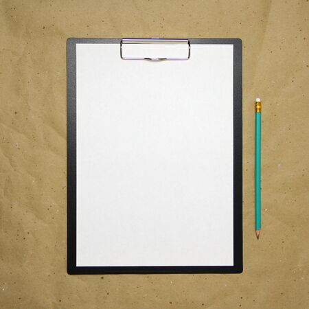 A tablet with a white sheet of A4 format with pencil on a beige craft paper. Concept of new opportunities, ideas, undertakings, innovations. Stock photo with empty place for your text and design.の写真素材