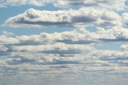 White fluffy clouds on a background of blue sky in summer. The concept of weather and climate.の写真素材