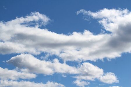 White fluffy clouds on a background of blue sky in summer. The concept of weather and climate.の写真素材