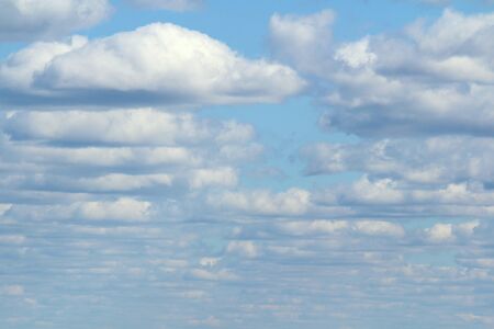 White fluffy clouds on a background of blue sky in summer. The concept of weather and climate.の写真素材