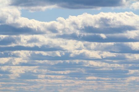 White fluffy clouds on a background of blue sky in summer. The concept of weather and climate.の写真素材