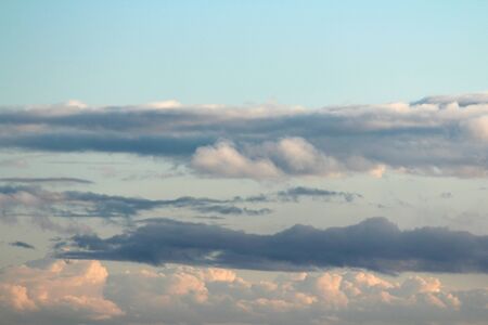 White fluffy clouds on a background of blue sky in summer. The concept of weather and climate.の写真素材