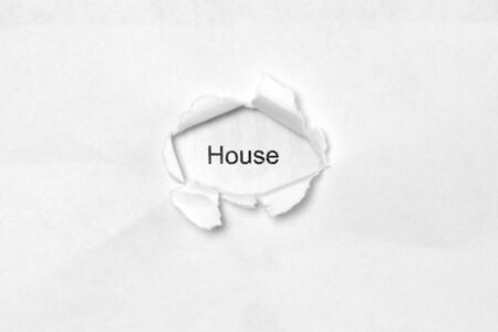 Word House on white isolated background, the inscription through the wound hole in paper. Stock photo for web and print with empty space for textの写真素材