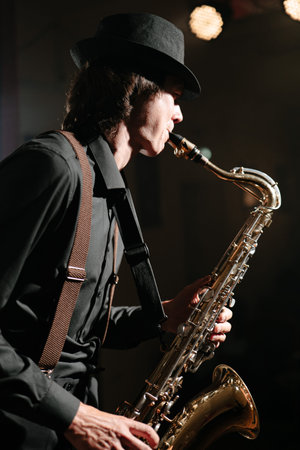 Man with saxophone. Saxophonist plays musical instrument