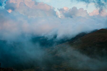 Clouds covered mountains few minutes after sunset. Blue hour. Cloudy dayの写真素材