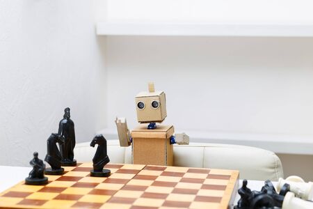 robot with hands sitting at the table playing chess. Artificial Intelligenceの写真素材