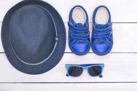 Children's accessories for the summer: sunglasses, hat, boots blue. Flat layの写真素材
