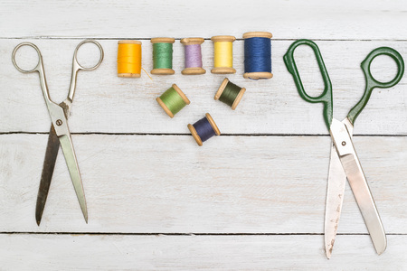 Top view on old scissors, cottons  on wooden desk