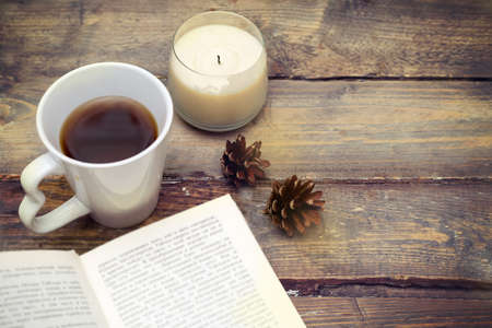 A cup of hot tea and a book on a wooden. Vintage toningの写真素材