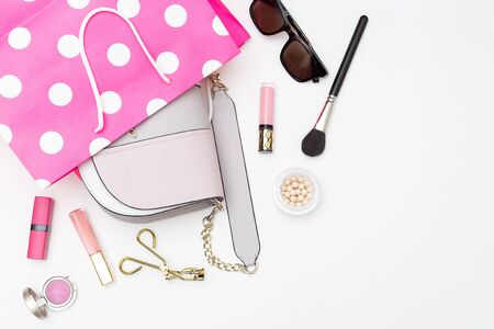 Handbag in a shopping bag and cosmetics on a white background. Flat layの写真素材