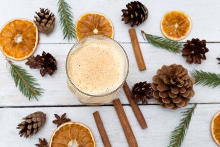 Homemade eggnog with cinnamon on wooden table. Christmas drinksの写真素材