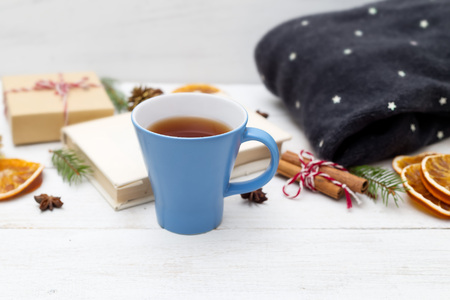 Blue cup with hot tea and Christmas decorations on a wooden background. Cozyの写真素材
