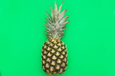 Tropical Pineapple fruit on a green background. Flat layの写真素材