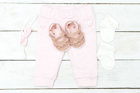 Clothes and accessories pink for baby girl on white wooden background. Flat layの写真素材