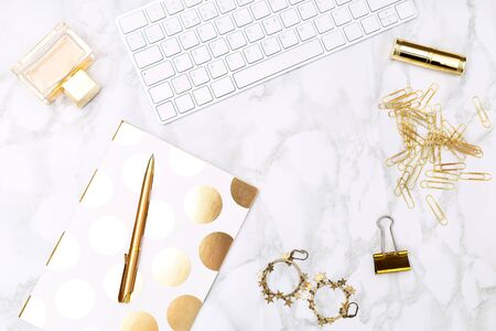 Keyboard c of office items of gold color and cosmetics on the desktop of the house. Flat layの写真素材