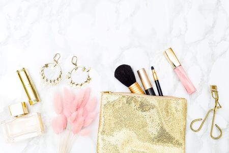 Makeup and accessories gold and pink for girls on the table.Copy space