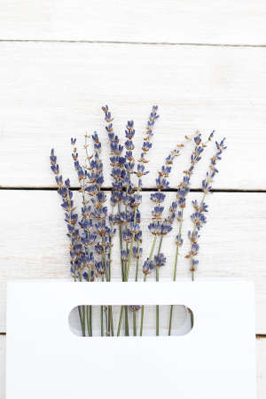 Bouquet of lavender in a paper white package on a wooden background. Vertical photoの写真素材