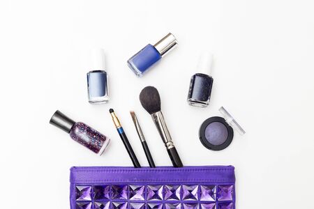 Female cosmetic bag and cosmetics of purple color on a white background. Flat lay
の写真素材
