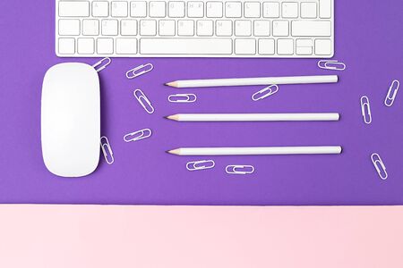 White computer keyboard and white computer mouse on an ultra violet background. Flat layの写真素材