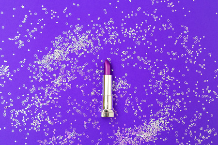 Purple lipstick on a background of ultra purple with sparkles. Flat layの写真素材