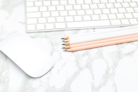 White keyboard and mouse on a marble background. Flat lay
