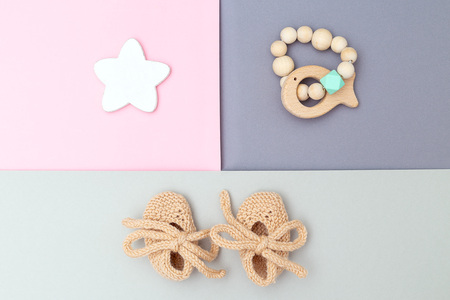 Baby's bootees and wooden toys on pastels colors background. Flat lay
