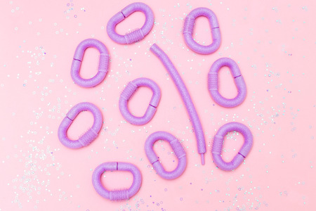Violet hair curlers  and glitter on pink background. Flat layの写真素材