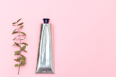 Lotion in metal tube on pink background. Copy spaceの写真素材