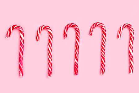 Christmas candy cane on pink background. Flat layの写真素材