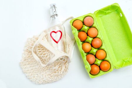 Reusable bottle and reusable mesh bag on white background. Sustainable lifestyle. Flat layの写真素材