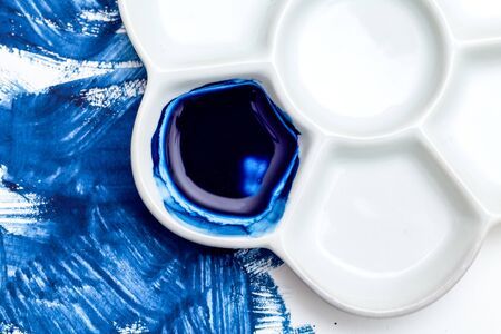 White ceramic palette and blue  paint. Color 2020.  Blue paint strokes.の写真素材