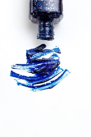 Nail polish blue with sparkles on a white background.  selective focus. Copy space. Vertical.の写真素材