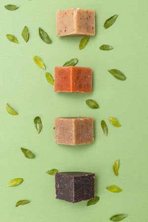Natural soap triangular pieces on green background. Vertical format. Organicの写真素材