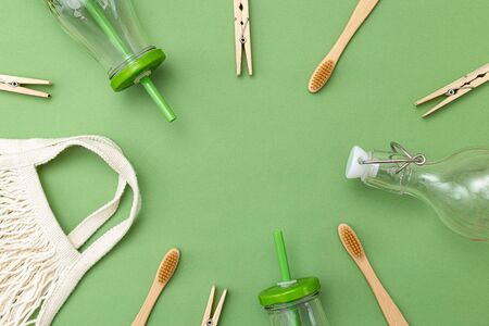 Sustainable lifestyle.  glass bottle and eusable bag on green background. Frame. Copy spaceの写真素材
