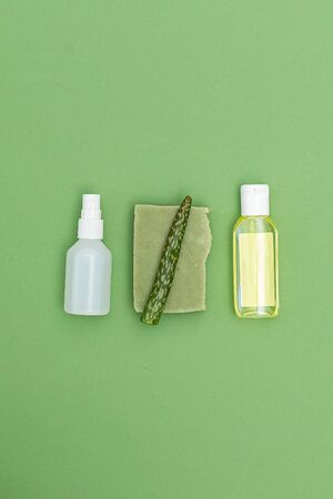 Hand gel and antiseptic spray with aloe vera on green background. Disinfection. Vertical format