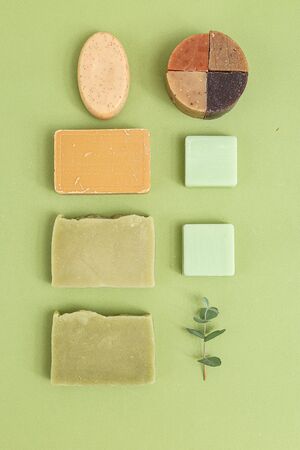 Natural soap and  eucalyptus on green background. Self-care. Minimalism. Vertical format