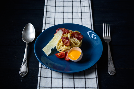 Pasta carbonara on a table with fresh products on dark background, copy space, food backgroundの写真素材