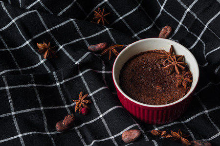 Delicious chocolate fondant with stars anise on black towelの写真素材