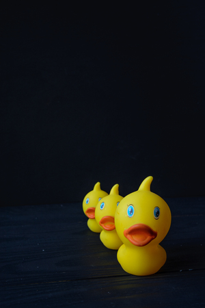 Yellow rubber ducks on black backgroundの写真素材