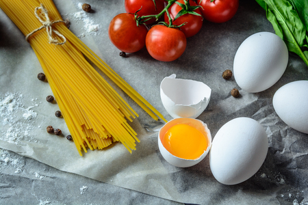 Food background with eggs pasta tomatoes and greensの写真素材