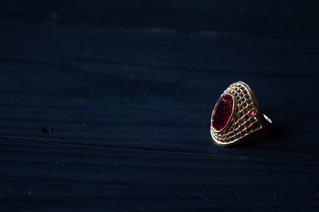 Golden ring with red stone isolated on a black backgroundの写真素材